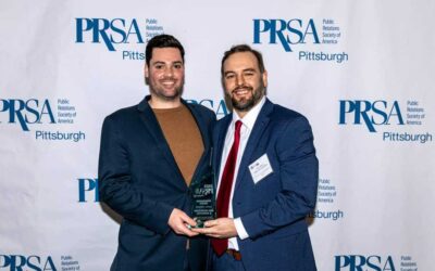Account Director William Berry & Marketing Manager Devon Moore holding PRSA Renaissance Award for Digital Marketing Campaign